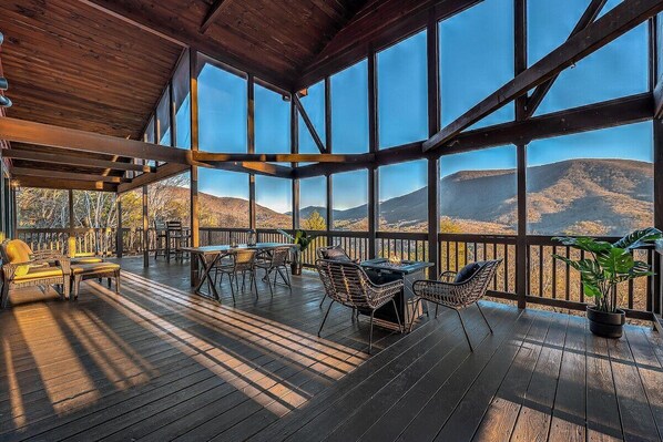 Expansive deck space with dining table, seating areas and gas fire pit. 