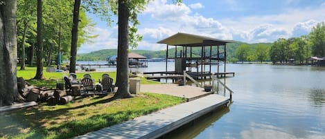 View from the boathouse.  Walk-in steps to the lake.  Depth is approximately 4 feet at the dock.  Firepit for relaxing and smores with a cozy fire later.  That's Blue Spring Marina across the bay.  Rent a boat there or drop your own and drive across