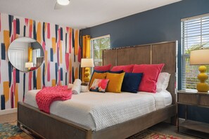 Vibrant bedroom with a king-size bed, colorful decor, and cozy, stylish vibes.