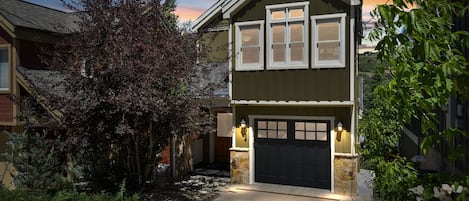 Exterior twilight of home from driveway with private garage