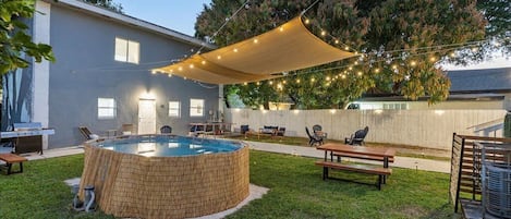 Backyard between both buildings with pool, BBQ and sitting areas.

