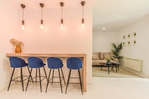 View of the dining area with high table , stools and the living room in the background