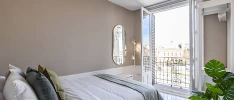 Main view of one of the bedrooms with a double bed and exterior balcony