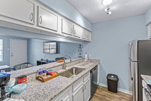 View of the kitchen area - sink, cabinets and ref