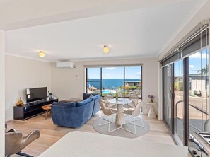 Unit 12 - Lounge and dining area showing view over pool and bay.