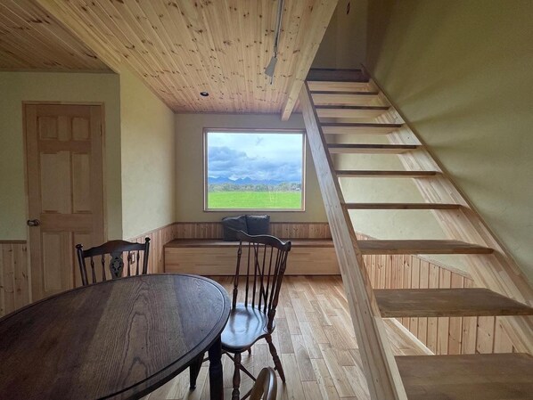 A living room with a large window with a mountain view that looks like a painting