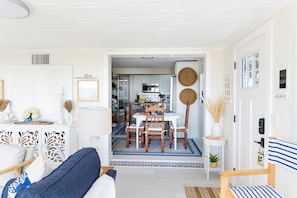 Clean, open floor plan from living and dining room with beachy themed interior.