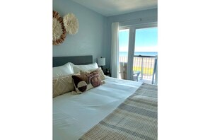 Master Bedroom with a king sized bed, ocean view, tv, closet and drawers