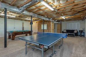 Basement game room with ping pong & pool table.