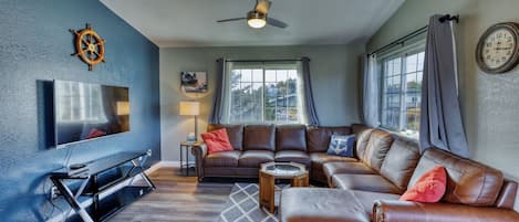 Welcome to 'The Wheelhouse,' where every detail invites you to embark on a journey of comfort and relaxation. Settle into our cozy living room with a mounted TV and plush leather couch. The boat captain's wheel adds nautical charm.