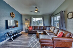 Welcome to 'The Wheelhouse,' where every detail invites you to embark on a journey of comfort and relaxation. Settle into our cozy living room with a mounted TV and plush leather couch. The boat captain's wheel adds nautical charm.