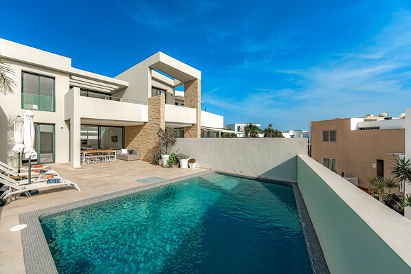 Heated private pool with comfortable sunbeds