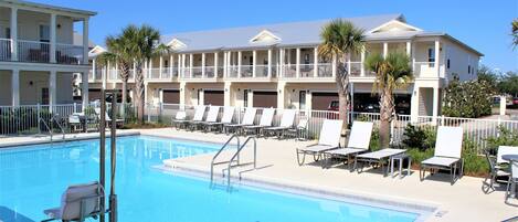 Large pool with lounge chairs and tables.