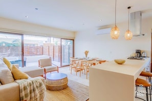 The open floor plan encompasses the kitchen, living and dining areas and is surrounded by floor-to-ceiling sliding glass doors