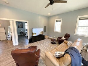 Living room with electric reclining couch and 65 inch smart TV.