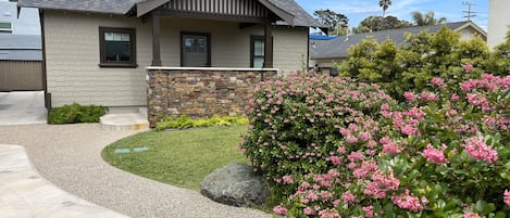 Front of cottage with potion of large patio parking area and lawn