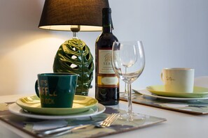 A close-up of the dining setup with an elegant lamp, wine glasses, and a cozy atmosphere.
