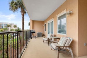 The balcony with comfortable seating and a gas grill