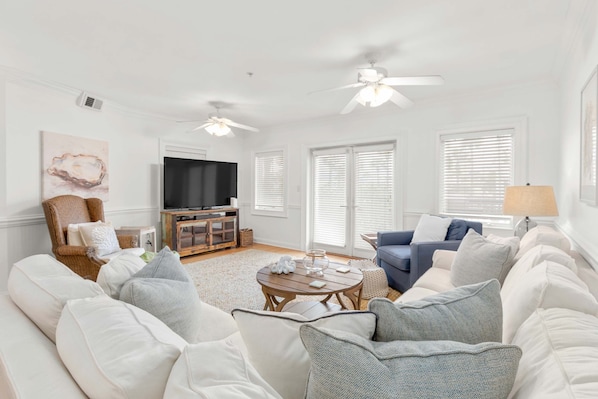The living area with a sleep sofa and large flat-screen TV
