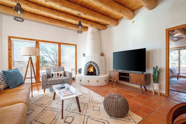 Living room with kiva fireplace, modern furniture, and large flat screen TV