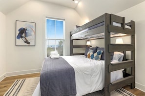 Our second bedroom has a bunk bed with a Queen-size bed on the bottom and a Twin-size bed on the top, a closet, a dresser, a 32-inch Vizio smart TV and a nearby bath.