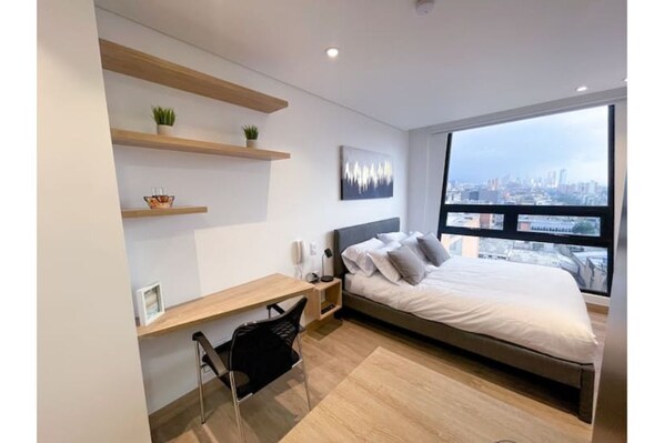 Habitación y escritorio con vista a la ciudad / Room and desk with city view