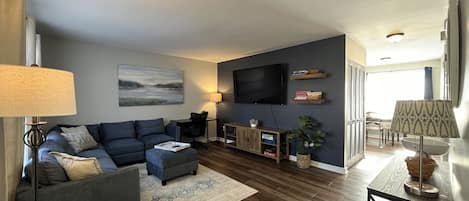 Large 75" Roku streaming TV, with a desk for home office use.