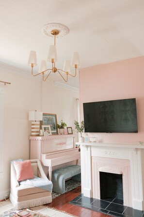 Dual living rooms with pink scalloped piano