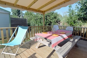 Enjoy the fresh air on the covered deck, where comfortable loungers and a picnic table invite you to unwind.