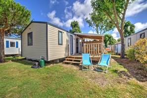 Embrace sunny days in this inviting outdoor space, perfect for lounging and unwinding amidst greenery and blue skies.