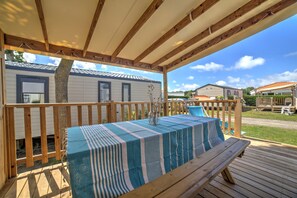 Relax on the covered deck, where a picnic-style table invites open-air dining with views of the lush surroundings.