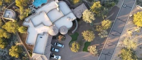 This home offers a stunning aerial view, showcasing its impressive size of over 5,000 square feet, along with a captivating yard and a separate guest home. It's truly an entertainer's dream!