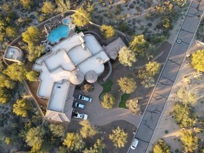 This home offers a stunning aerial view, showcasing its impressive size of over 5,000 square feet, along with a captivating yard and a separate guest home. It's truly an entertainer's dream!