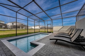 Relax in your private screened pool oasis with comfortable loungers and enjoy the serene surroundings.