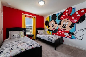 Delight in this vibrant, cartoon-themed bedroom with twin beds and a playful mural, perfect for a magical family getaway!