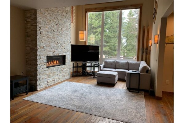 This luxe living room boasts a cozy fireplace and picturesque views.