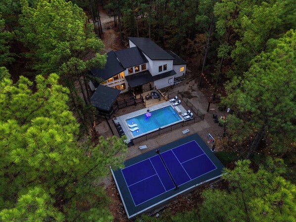 Newly completed 16x34 pool is now ready with optional heating, a serene tanning ledge with bubblers, dual pickleball/basketball court & a 6 hole GLOW Golf Course!
