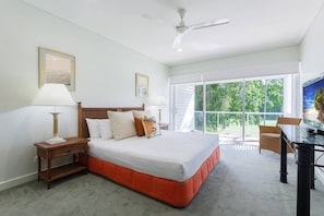 The primary bedroom offers a comfortable queen bed under the cooling breeze of central air-conditioning and a ceiling fan.