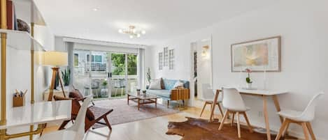 The bright, spacious living room, with dining area and work space.