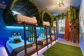 Jungle-themed bunk room with glowing beds, tree murals, and forest vibes.