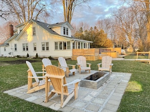 Large fire pit with 6 cedar Muskoka chairs overlooking the lake.