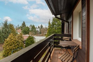 A balcony with outdoor seating offering scenic views of a peaceful neighborhood.
