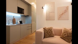 Main area with a fully equipped kitchenette, dining area for 4, a comfortable sofa and a flat screen TV. #dining #kitchen #livingroom #lovelystay