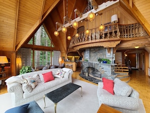 Living room with upper reading loft above stone fireplace