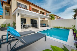 pool-side loungers in private backyard