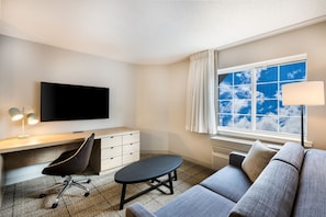 Spacious living room with a sofa bed and a workspace.