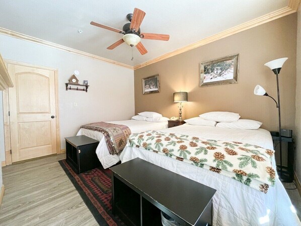 Imagine unwinding in this cozy retreat, where you can sink into plush beds adorned with nature-inspired linens. The warm wood tones and soft lighting create an inviting ambiance perfect for restful nights. (Large bedroom with with 2 full size beds)