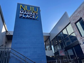 Through the parking lot look for this Nulu Marketplace sign leading the way to the courtyard where your vacation stay awaits