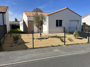 Entrée de la maison, vue rue, parking privé devant garage