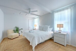 Spacious master bedroom with natural light and cozy decor.